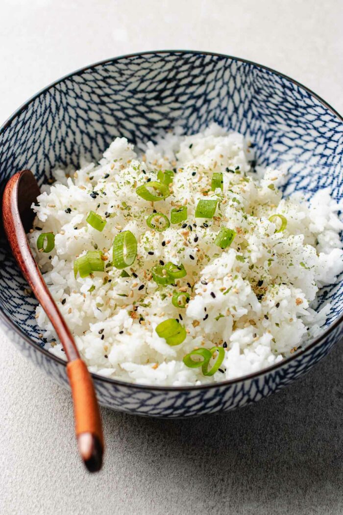 Photo shows rice grains cooked to perfection in an air fryer and served in a blue white color bowl