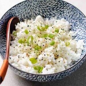 Recipe image shows air fryer rice with basmati rice served in a blue white color bowl