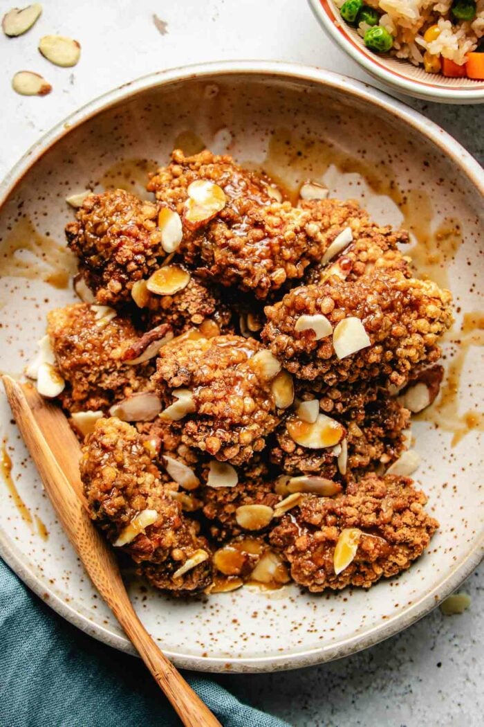 Photo shows copycat Panda Express almond chicken dish with crispy chicken breast and almond coated in a sweet savory sauce,