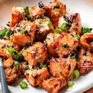 A recipe image shows bang bang salmon bites air fried or oven baked and served on a light gray color plate.