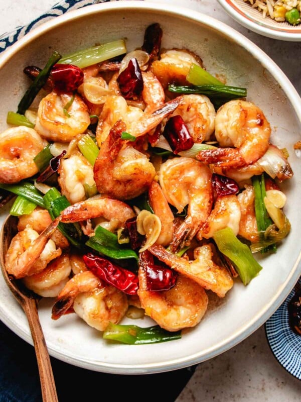 Photo shows Mongolian shrimp with velveted shrimp stir fried with ginger, spring onions, and chili peppers served in a white plate.