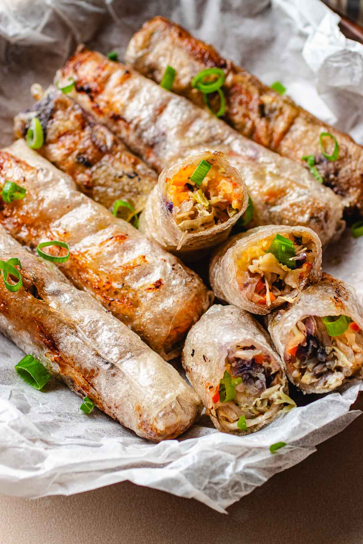 Rice paper egg rolls with vegetables inside and fried to crispy.