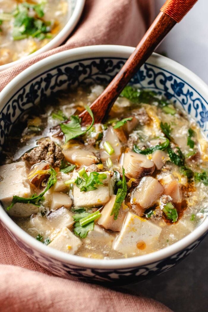 Photo shows West lake beef soup served in a Chinese style blue and white color soup bowl