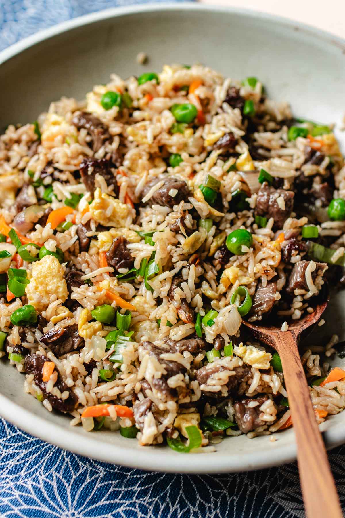 A side close shot image shows fried rice and steak Chinese style served on a plate.