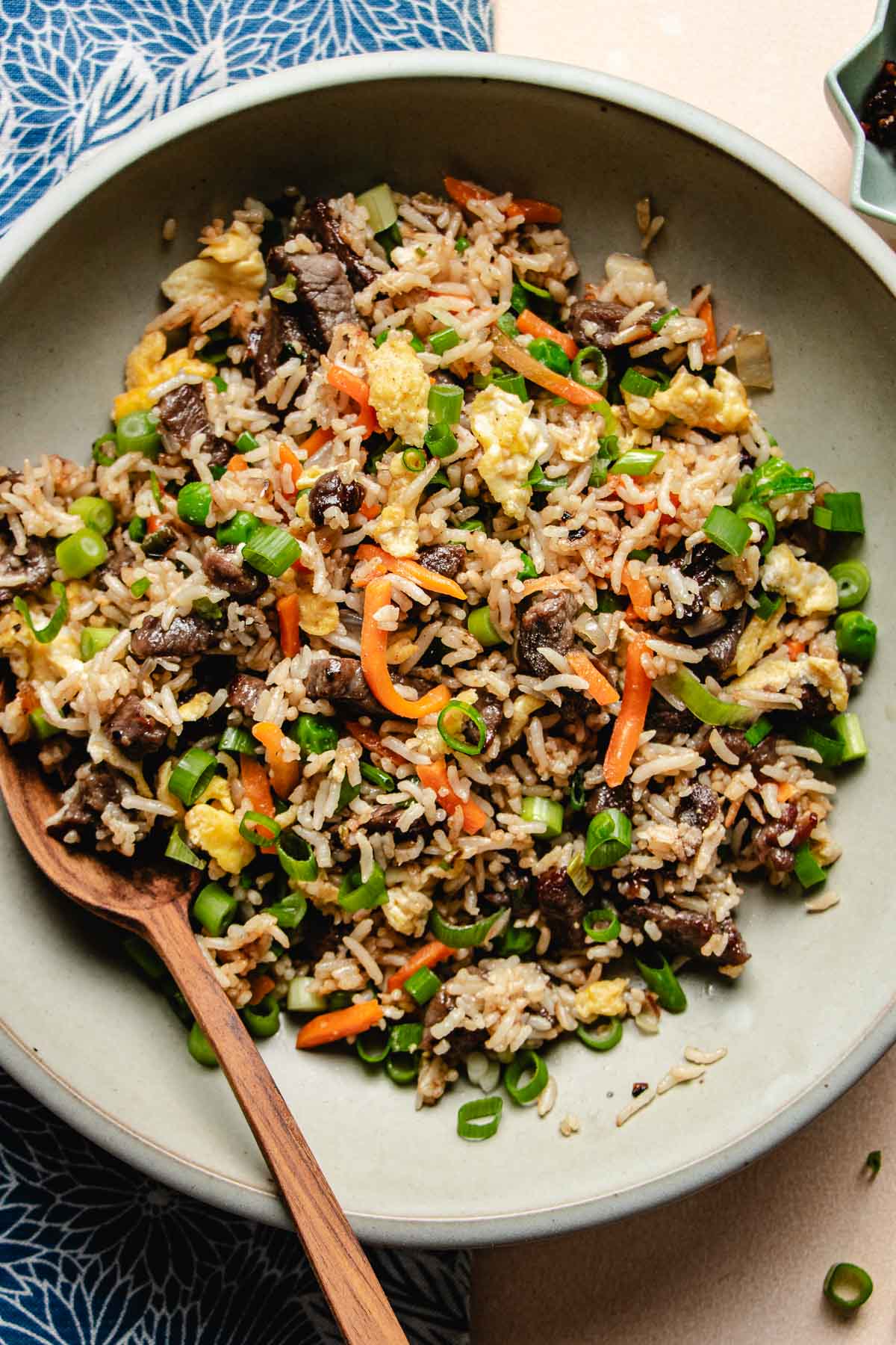 Feature image shows tender steak marinated and stir fried with rice served on a light gray color plate.