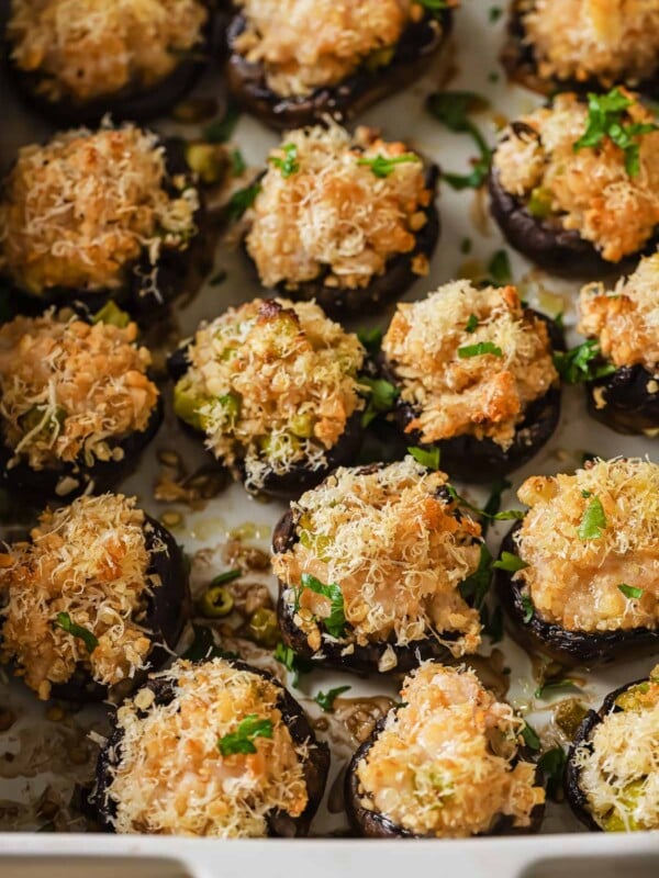 Photo shows mushrooms stuffed with shrimp seafood filling and baked in a casserole dish.