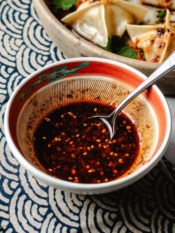 Image shows wonton dipping sauce mixed well in a small serving bowl with a serving spoon.