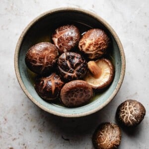 Recipe image shows shiitake dry mushrooms soak in a bowl of liquid to rehydrate.