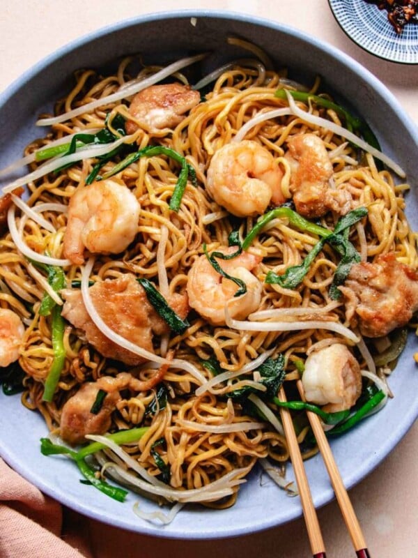 Image shows crispy chow mein noodles house special with chicken and shrimp served in a light blue color plate.