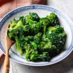 Recipe image shows broccoli with garlic sauce Chinese takeout style served in a blue white color plate.