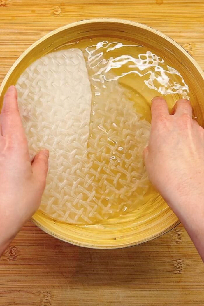 Person demos how to properly dip rice paper into the water.