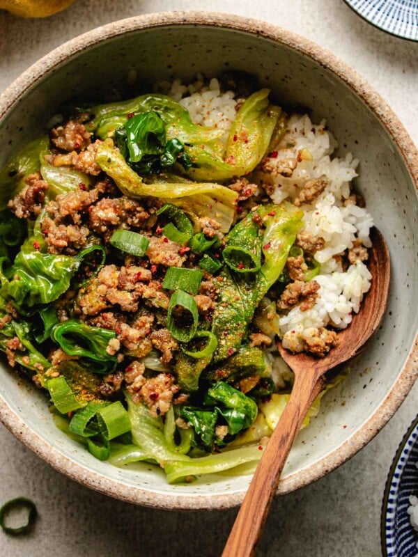 An overhead close shot image shows a bowl of delicious ground pork stir fry with miso sauce and crisp lettuce served over rice.