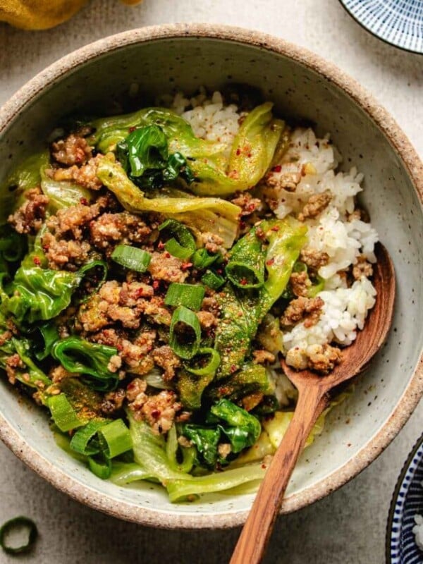 An overhead close shot image shows a bowl of delicious ground pork stir fry with miso sauce and crisp lettuce served over rice.