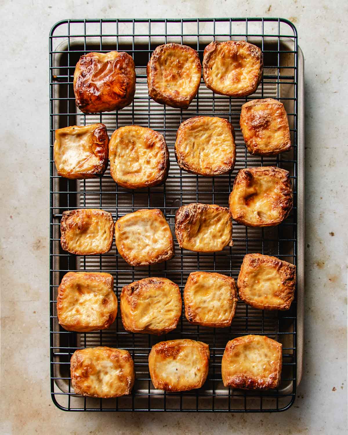 Photo shows cooling puffed tofu over a wire rack after frying.