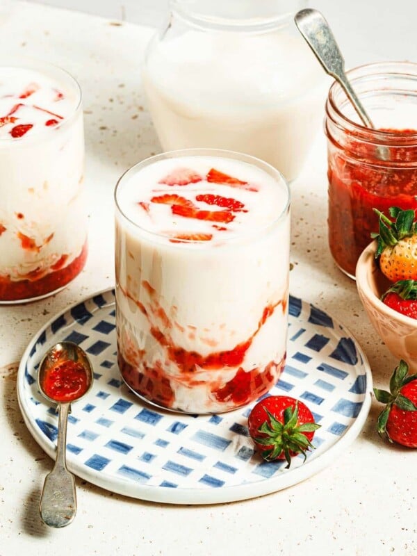 Photo shows two glasses of Korean strawberry milk with strawberry syrup swirl in the cup.