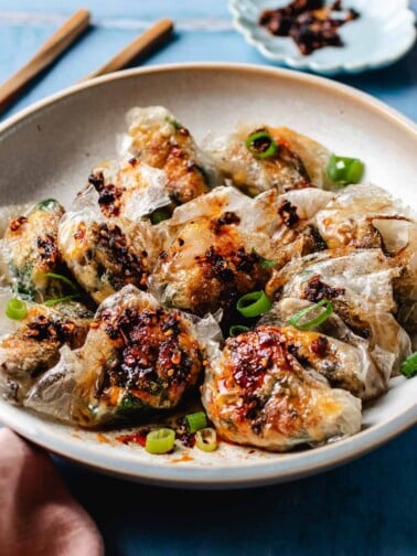 Feature image shows a plate of crispy dumplings made with rice paper wrappers with garlic chive filling inside.