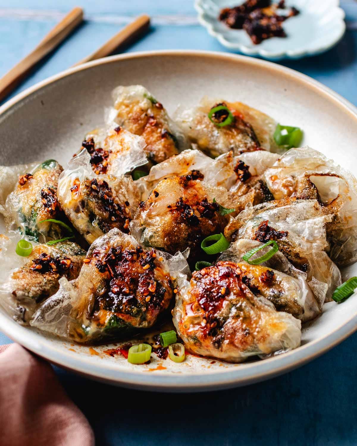 Feature image shows a plate of crispy dumplings made with rice paper wrappers with garlic chive filling inside.