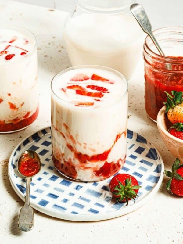 Photo shows two glasses of Korean strawberry milk with strawberry syrup swirl in the cup.