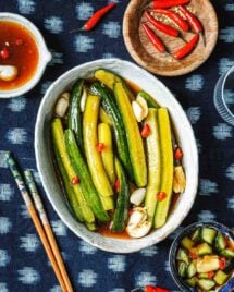 Feature image shows Persian cucumbers sliced to spears and marinated with Asian pickling juice and served in a white oval plate.