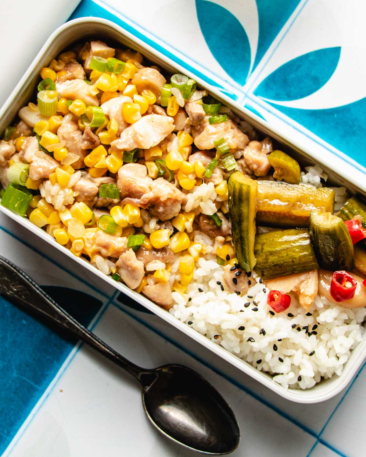 Image shows a meal box with chicken and corn with rice in a lunch box.