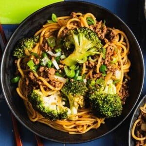 Recipe image shows Asian ground beef noodles stir fried with broccoli and served in a pasta plate.