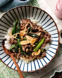 An overhead image shows Chinese beef with garlic sauce with tender beef stir fried in rich garlic sauce, served over a bowl of white rice.