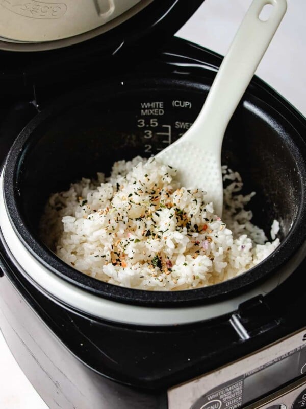 Image shows fluffy white rice made from a rice cooker and fluff with a rice paddle.