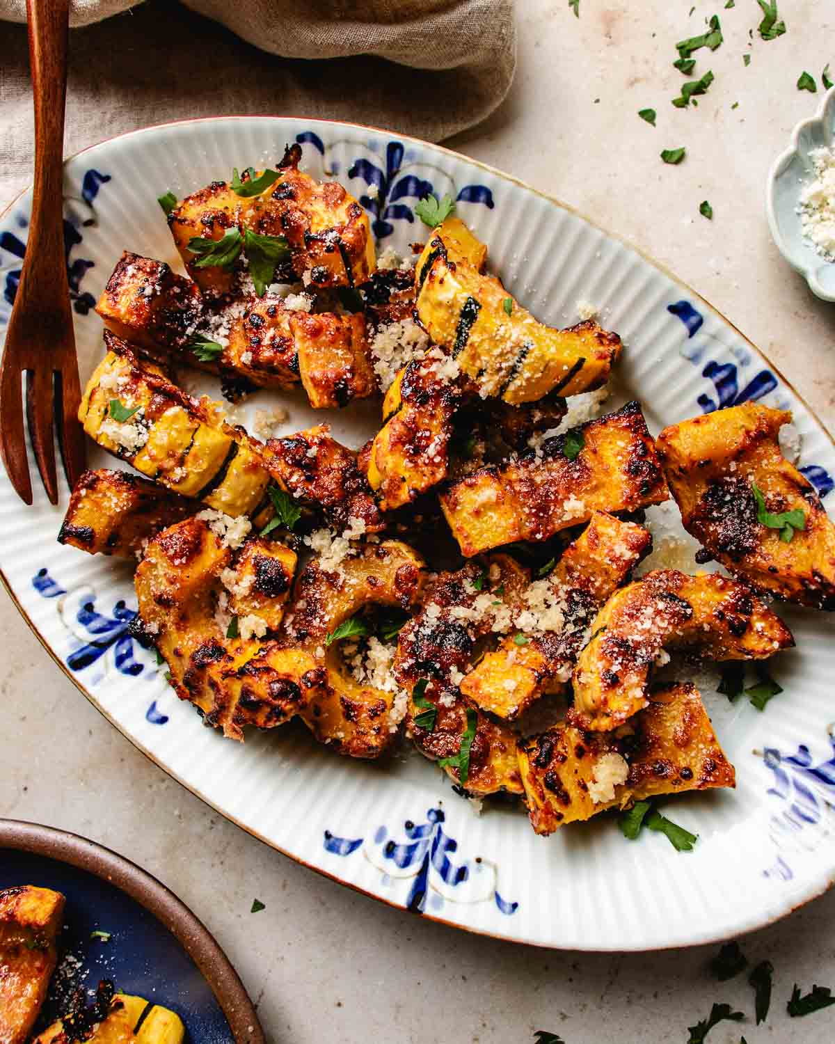 Feature image shows perfectly air fried delicata squash with honey parmesan crust served on a blue white color plate.