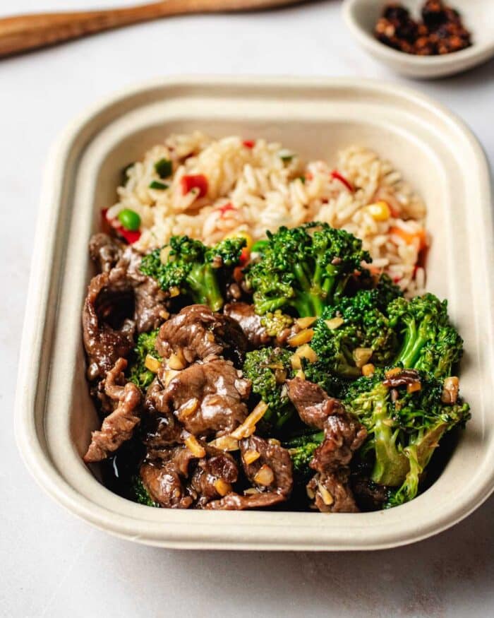 Image shows Panda Express takeout style broccoli beef served in a takeout box with Panda fried rice on the side.