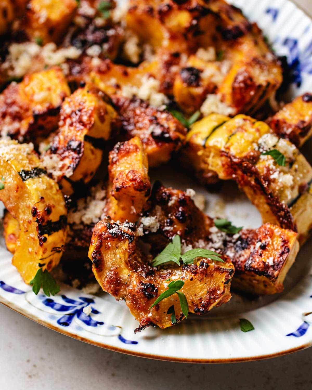 A side close shot shows caramelized delicata squash made in an air fryer with parmesan and honey on top.