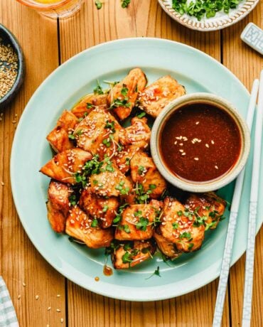 Feature image shows honey sriracha salmon bites with extra sriracha honey sauce served on the side.