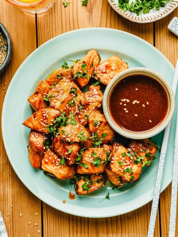 Feature image shows honey sriracha salmon bites with extra sriracha honey sauce served on the side.