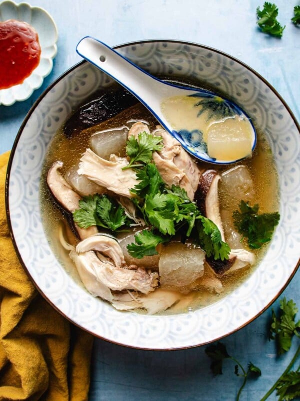 Image shows a bowl of Chinese winter melon soup with chicken and shiitake in a soup bowl.