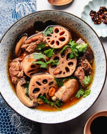 Feature image shows a bowl of lotus root soup with baby pork ribs and broth served in a soup bowl.