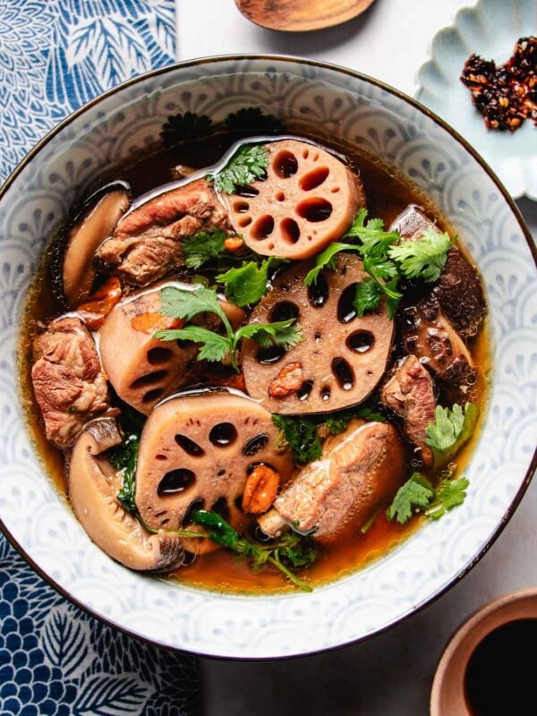 Feature image shows a bowl of lotus root soup with baby pork ribs and broth served in a soup bowl.