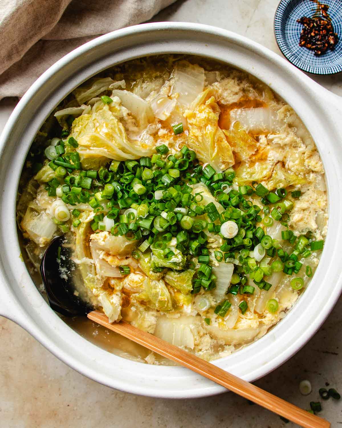 Feature image shows a pot of Napa cabbage soup with egg ribbons in a claypot.