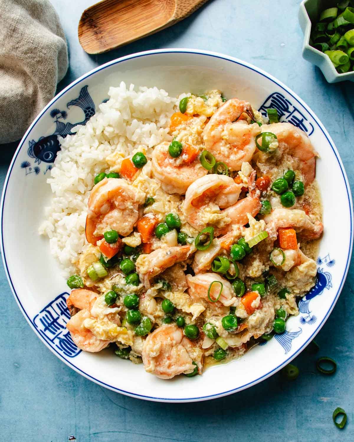 An overhead image shows shrimp and lobster sauce served in a bowl of rice.