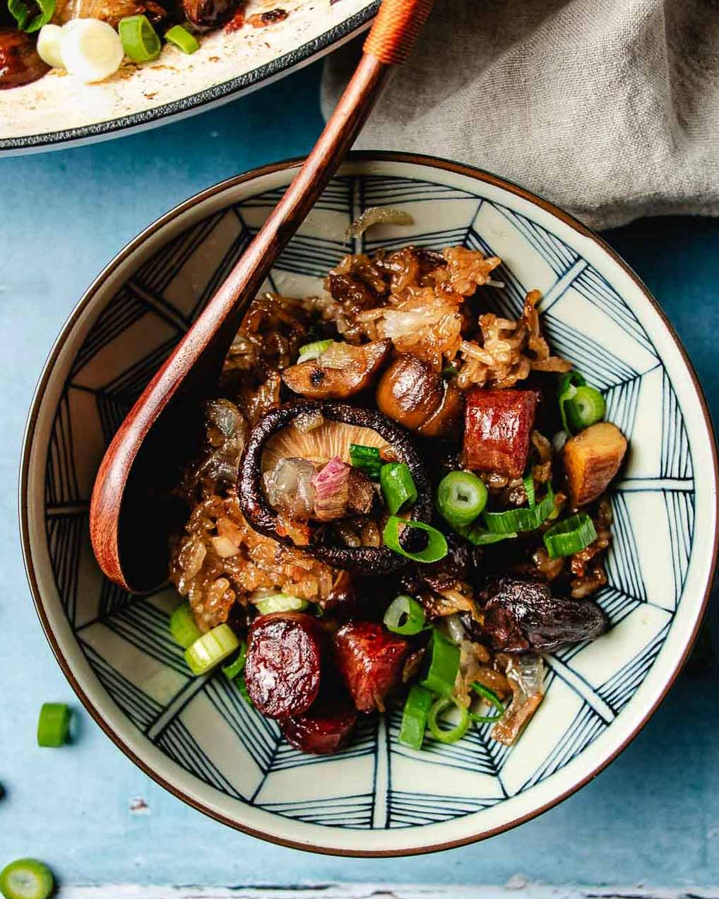 Feature image shows a bowl of Chinese sticky rice stuffing with sausage, shiitake, chestnuts served in a blue white color bowl.