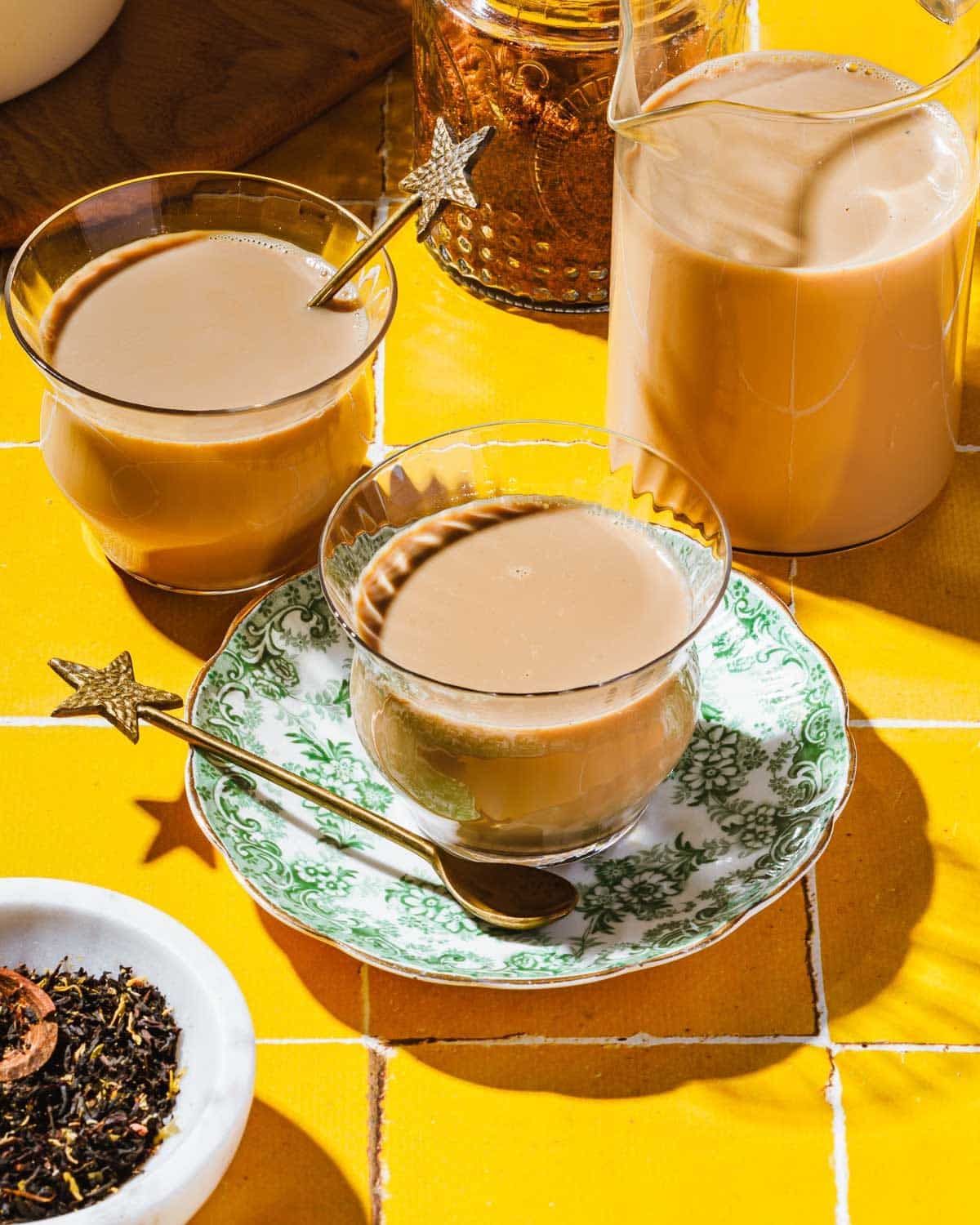 Feature image shows a cup of Japanese royal milk tea served in a teacup with extra glasses on the side.