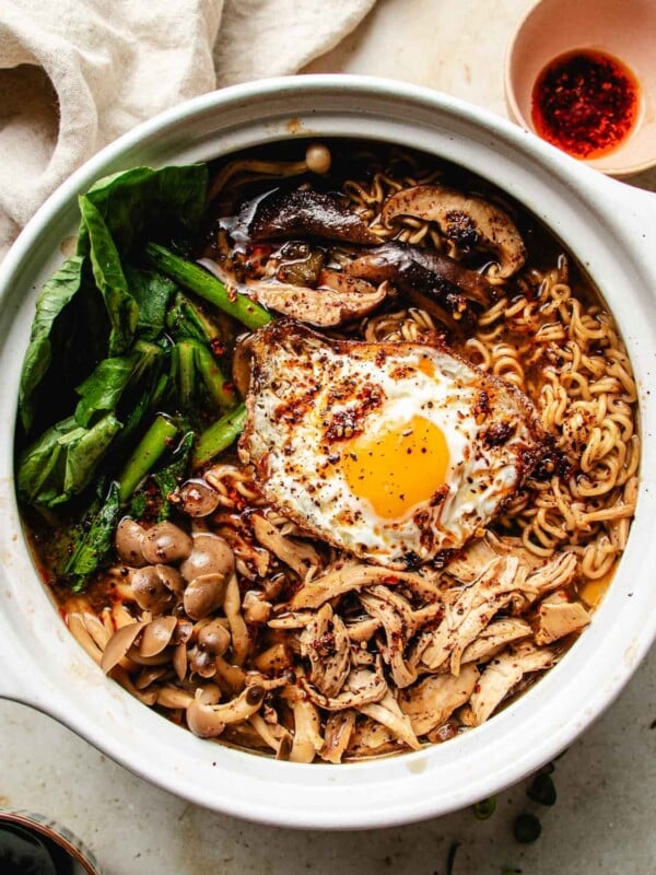 Feature overhead image shows spicy chicken noodle soup in a donabe soup pot with ramen noodles, cooked chicken, mushrooms, and vegetable, plus a fried egg on top.