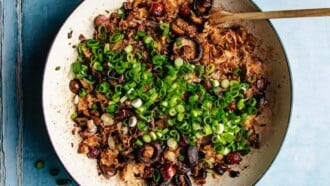 Image shows sticky rice with Chinese sausage and chestnuts lightly baked to crispy in a casserole pan.