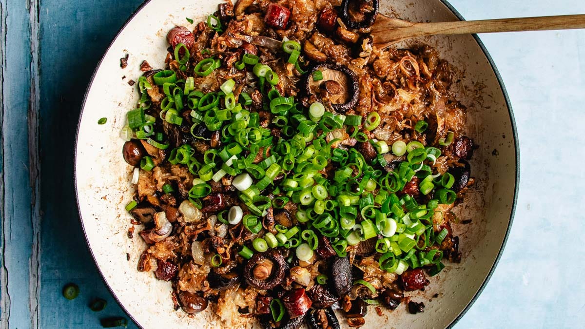 Image shows sticky rice with Chinese sausage and chestnuts lightly baked to crispy in a casserole pan.