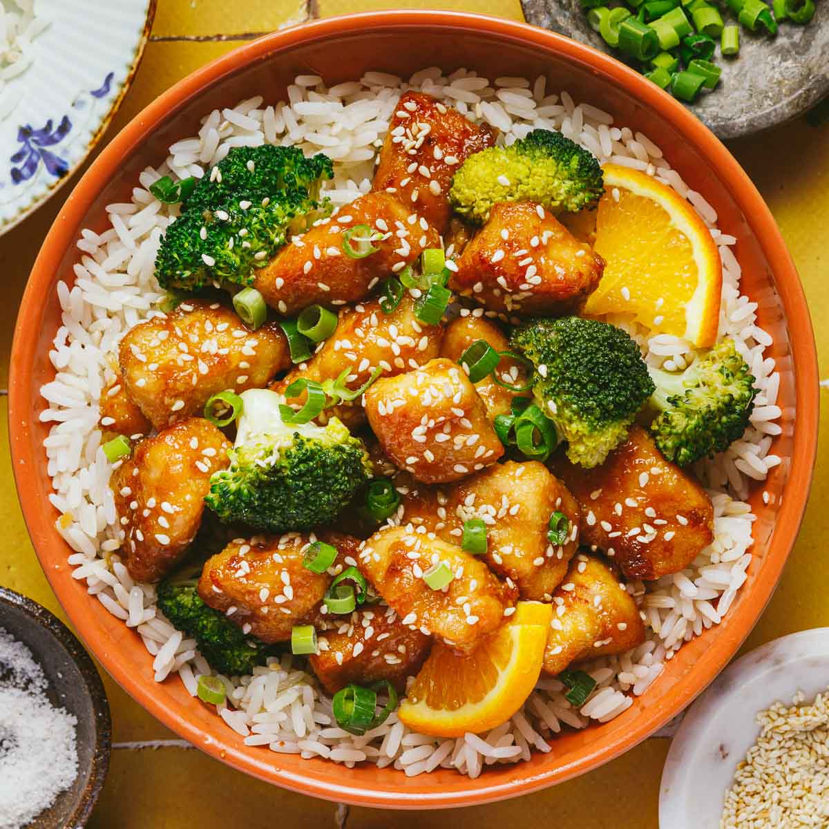 Recipe image shows a bowl of delicious air fried orange chicken with rice and vegetables in a orange color bowl.