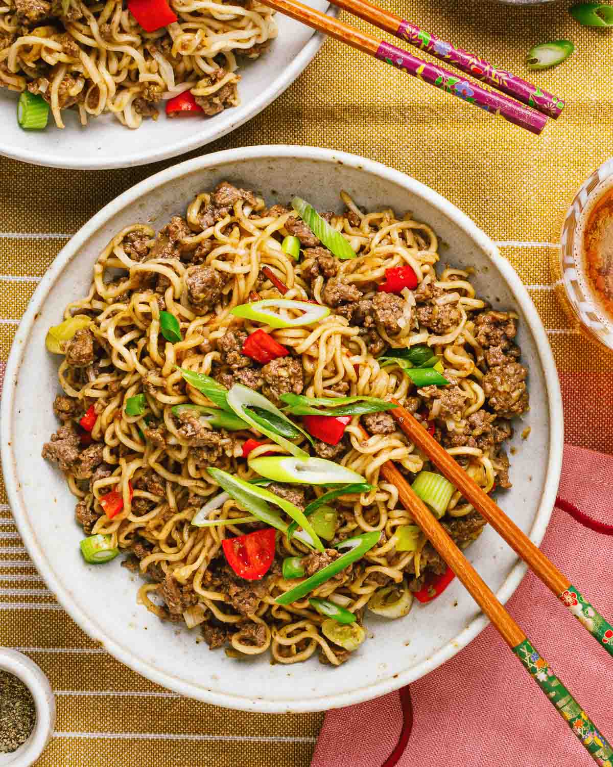 Overhead feature image shows a plate of noodles stir fry with ground beef and coated in Mongolian sauce.