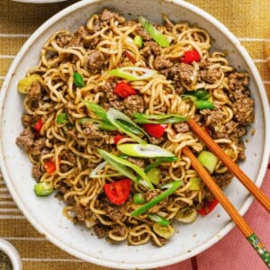 Recipe image shows Mongolian ground beef noodles in a white serving plate with chopsticks.