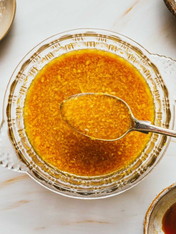 Feature image shows orange sauce made simple at home in a glass bowl with a spoon.