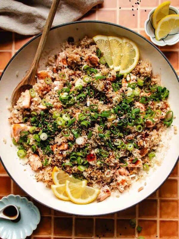 Overhead feature image shows a big pan with crispy rice and tender salmon with sweet soy glaze garnish on top.