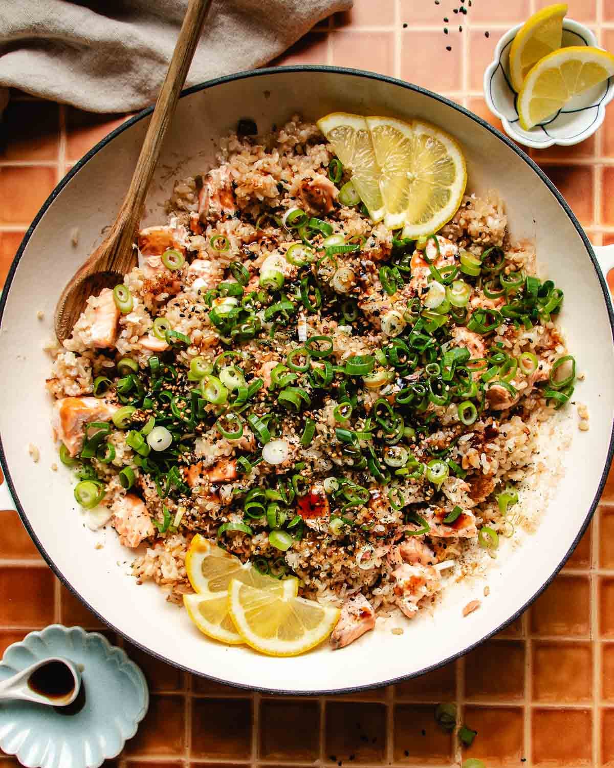 Overhead feature image shows a big pan with crispy rice and tender salmon with sweet soy glaze garnish on top.