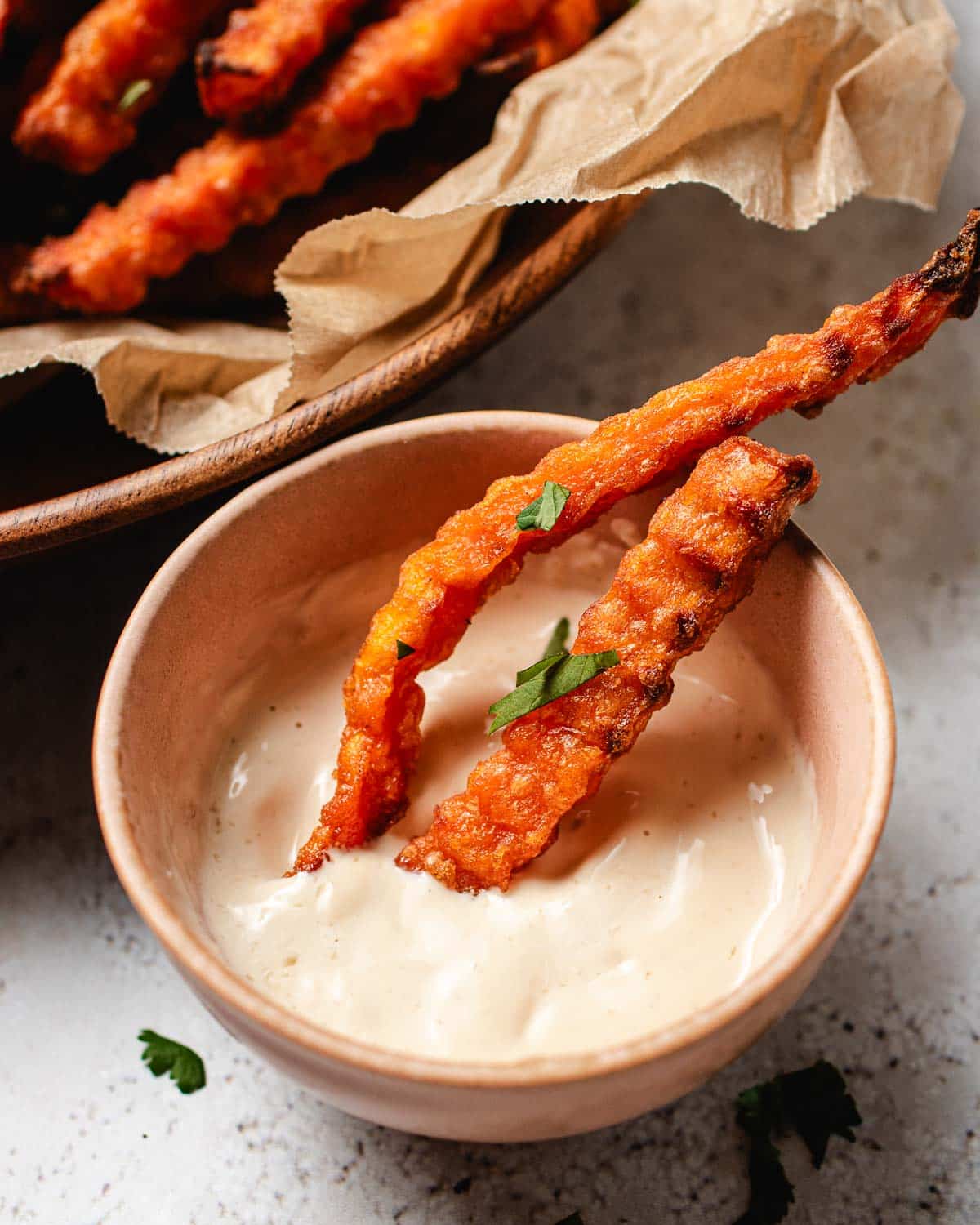 A side close shot shows crispy frozen yam fries dipped in a creamy dipping sauce.