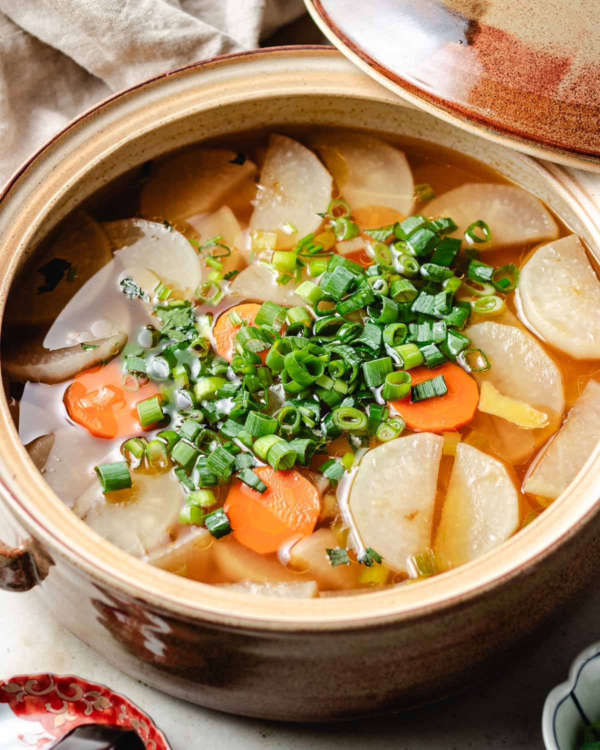 a side close shot shows the clear daikon soup in clear chicken broth.